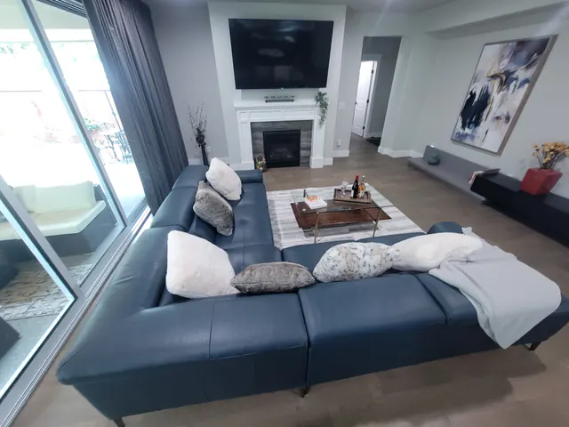 Restored great room with sectional sofa, fireplace and new flooring