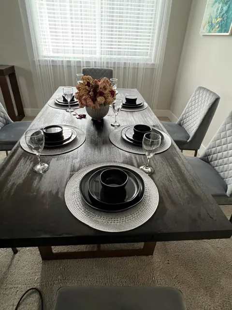 Dining table top covered in water spots and debris from the ceiling